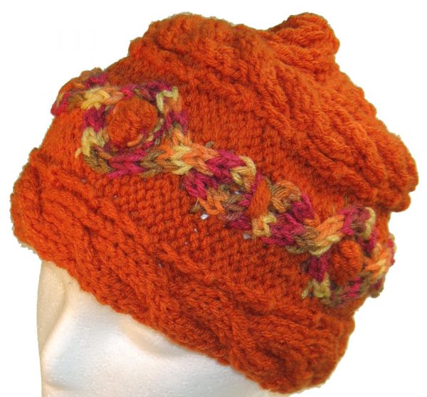 Orange hand knit hat with multi-color cable